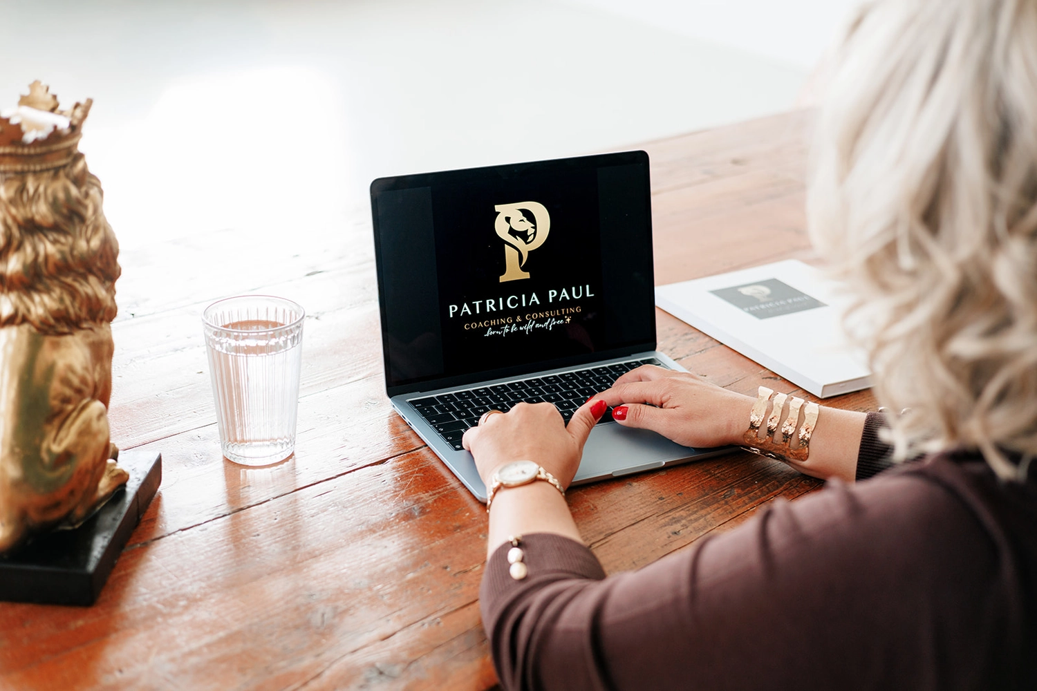 Patricia Paul – Coaching & Beratung – eine Person arbeitet an einem Laptop, auf dem das Logo und der Name von Patricia Paul Coaching & Consulting zu sehen sind.